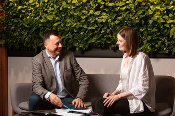 Two business partners laughing together while discussing documents in a modern office. Friendly...