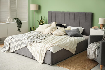 Modern bedroom with bed, bedside tables, armchair and lamp