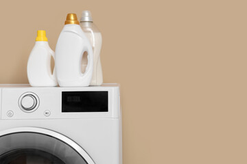Fototapeta na wymiar Modern washing machine with detergents on beige background, closeup