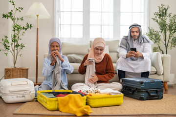 Muslim family preparing luggage for travel trip packing clothes into suitcase for international,...