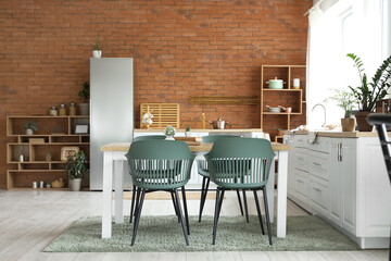 Interior of modern kitchen with dining table and fridge
