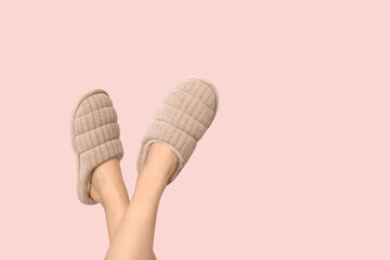 Female feet in slippers on pink background