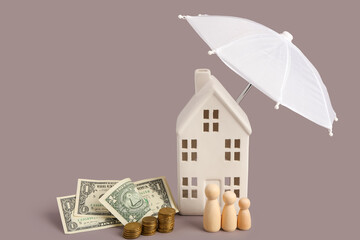 Composition with decorative house, mini umbrella, money and wooden figures of family on grey...