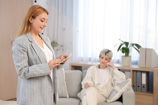 Female adolescent psychologist with tablet computer in office