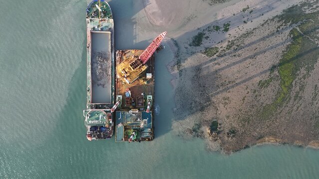 Aerial View of Dredging Barge and Crane at Coastal Construction Site