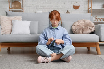 Teenage girl buttoning up shirt at home