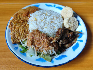 Nasi pecel or sego pecel is a typical Javanese Indonesian dish served with pecel sauce, which can be added with vegetables, peyek, fish, crackers, tempeh and other side dishes.