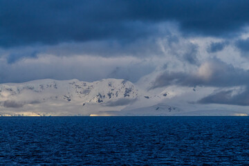 An Antarctic landscape, taken during the golden hour, just after sunrise, in the Gerlache Strait.