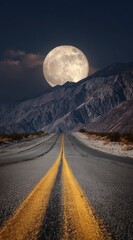 Empty highway under a full moon, mountains