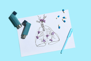 Lungs drawing with asthma inhalers, lilac flowers and pills on blue background