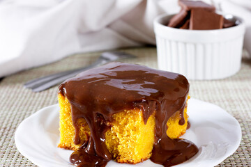 Slice of carrot cake with chocolate frosting on a ceramic plate. homemade Brazilian dessert