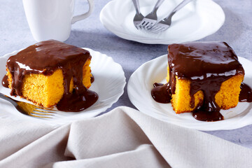 Slice of carrot cake with chocolate frosting on a ceramic plate. homemade Brazilian dessert