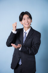 スーツを着たビジネスマンの若い男性水色　思い付く、閃く、わかったアイデア 縦　カメラ目線