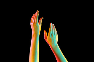 Toned female hands on dark background