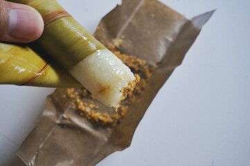 Lepet is a snack made from sticky rice and grated coconut and seasoned with salt, wrapped in young coconut leaves, cylindrical in shape and boiled. Indonesian food.
