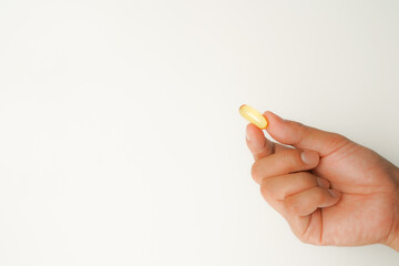 Male hand holding soft gels, Fish oil capsules, omega 3, omega 9, vitamin D, vitamin E, supplements