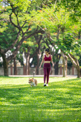 A woman is walking her dog in a park