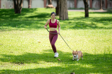 A woman is walking her dog in a park