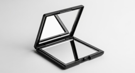Open black compact mirror with two reflective surfaces