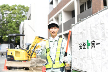 建設現場でガッツポーズをする交通誘導員