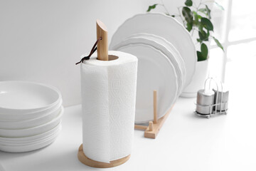 Roll of paper towels with plates on table in kitchen