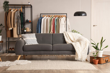 Interior of living room with clothes racks and sofa