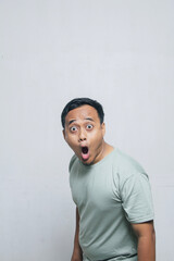 Asian Man's Surprised Expression with Mouth Wide Open with moss green t-shirt and wide forehead