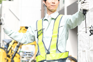 工事現場で交通誘導をする現場作業員のイメージ