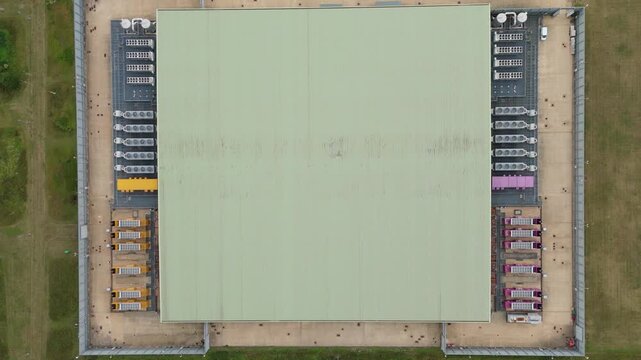 Top down aerial drone view of large data center in England, UK futuristic cutting edge technology with cooling fans and quantum computing data storage.