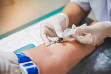 Close up hand of nurse, taking blood sample from a patient in the hospital.	