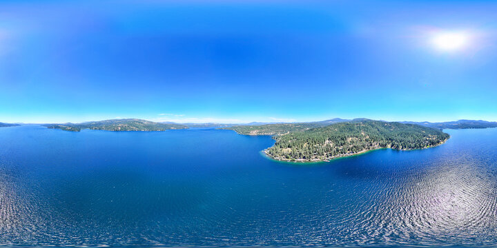 Aerial view captured by drone of the deep blue water at lake coeur d'alene in Harrison, Idaho. The water is calm and is a popular tourist destination for water sports. 