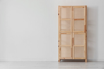 Wooden closet near light wall in room