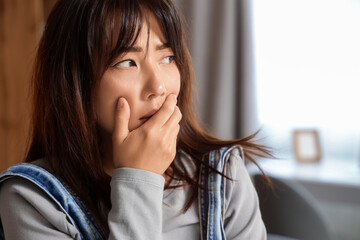 Young Asian woman with suicidal thoughts at home, closeup