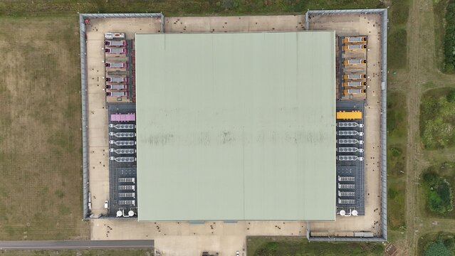 Aerial top down view of large futuristic cutting edge technology data center in England, with cooling fans and turbines, quantum computing and data storage.