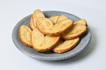 Close up view of many mini pies on grey or gray plate isolated on white background. Clipping path. Love sign. Pastry. Danish. Butter. Heart.