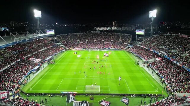 Spectacular Aerial View of a Packed Soccer Stadium at Night During a Pre-Game Ceremony with Parachutes.