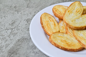 Extreme Close up view of many mini pies on white plate isolated on grey or gray cement background. Love sign. Copy space, empty, free, negative, Half. Danish. Pastry. Butter. Heart.