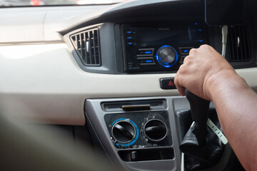 Driver's hand operating gear shift inside a compact car. Useful for concepts like road trip, manual...