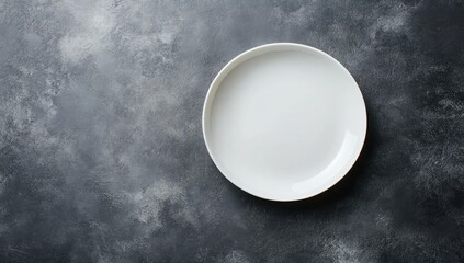 Empty white plate on dark gray mottled surface