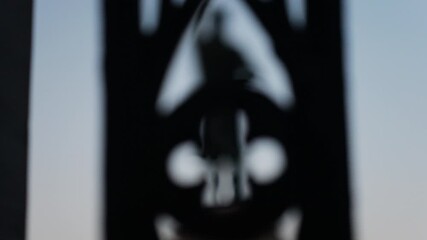 Chisinau, Moldova - June 15, 2025: Stephen the Great statue seen through the out-of-focus curves of a wrought-iron fence