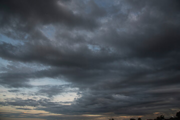 Dark rain cloud dramatic sky summer tropical thunder storm sky and fluffy black darkness cloud...