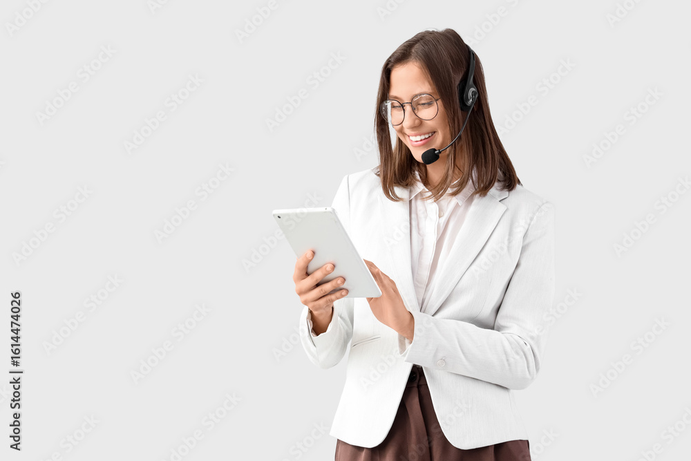 Poster female technical support agent working with tablet computer on light background