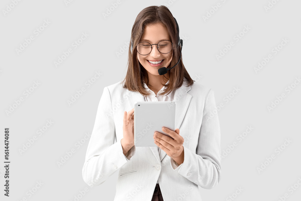 Poster female technical support agent working with tablet computer on light background