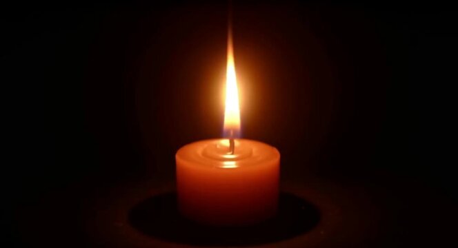 calmly flickering candle flame in darkness creating a peaceful ambiance