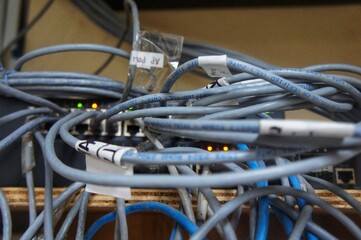 Close-up of a bundle of colorful Internet LAN cables connected to network equipment, showing the details of the messy cables.