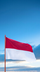Closeup view of the Indonesian national flag waving with a blue sky background. Celebrate Indonesia Independence Day. Concept of Kemerdekaan Indonesia