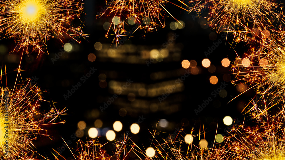 Poster sparkling border of glowing sparklers against a bokeh blurred backdrop of lights at night. copy spac