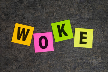 woke word symbol on colorful sticky notes on dark background