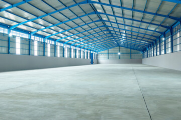 Large and empty warehouse interior with a high ceiling, metal structure, and concrete floor....