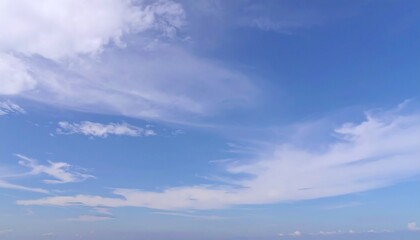 Serene expanse of cirrus clouds drifting lazily across a tranquil blue sky vista